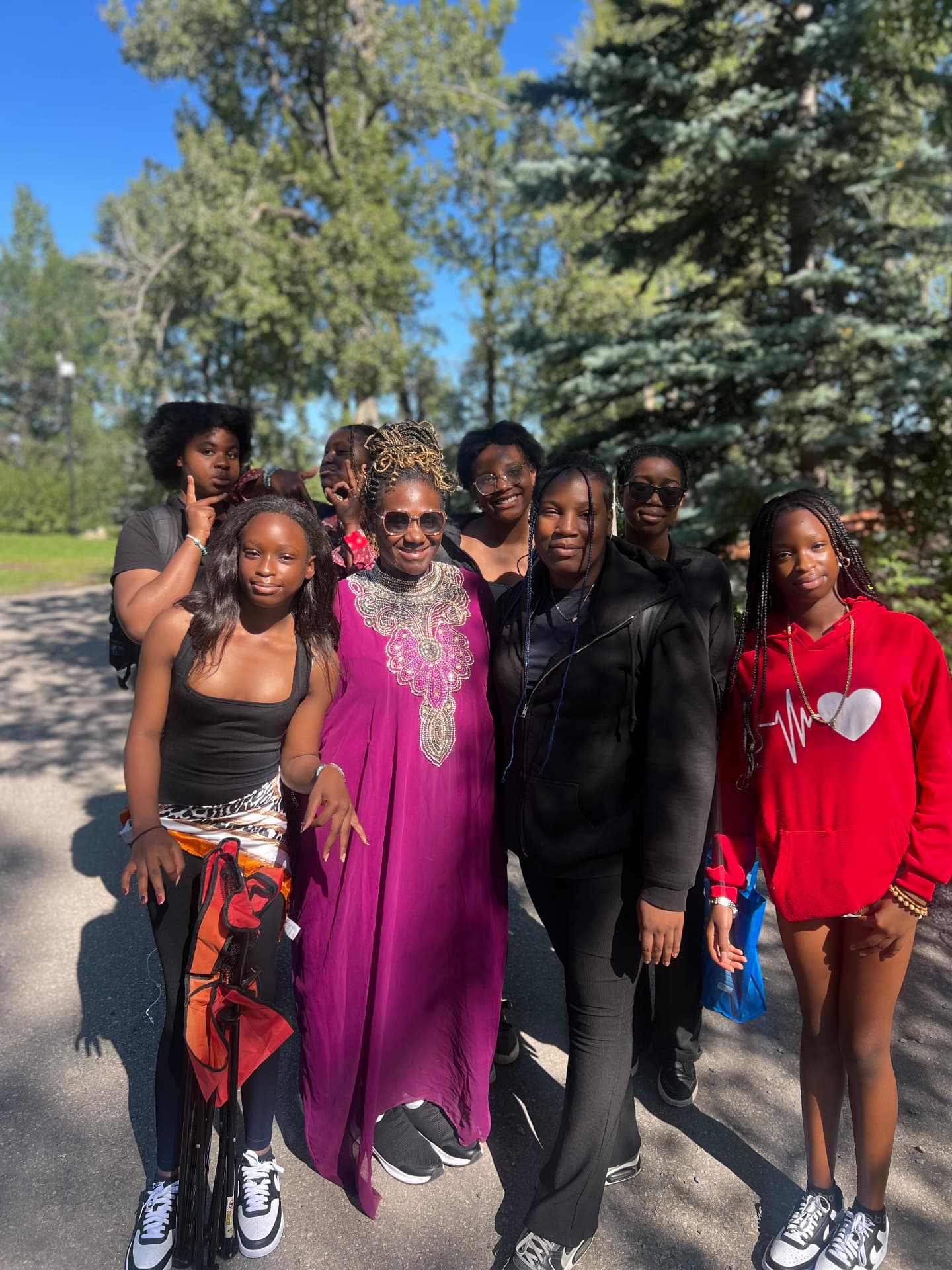 Students standing with the founder outdoors at a community event