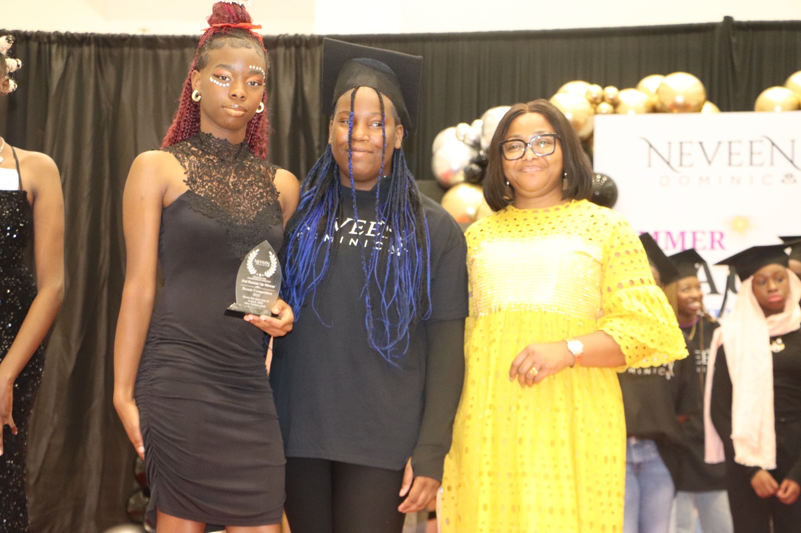 A student receives a Beauty Competition award on stage at the graduation ceremony