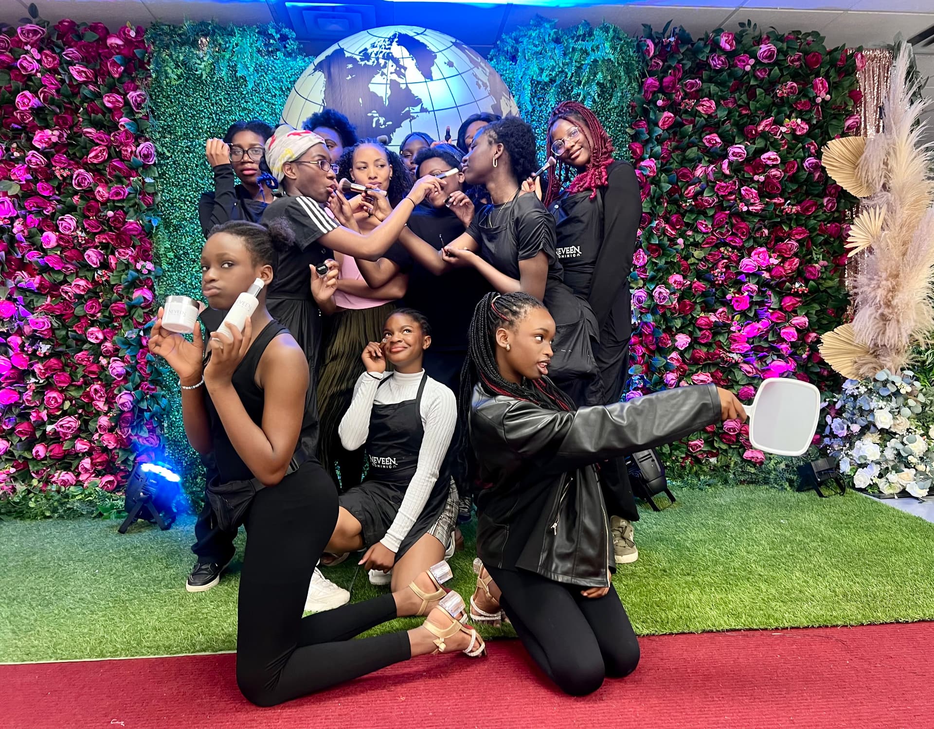 The camp team celebrates together in front of the flower wall after the show