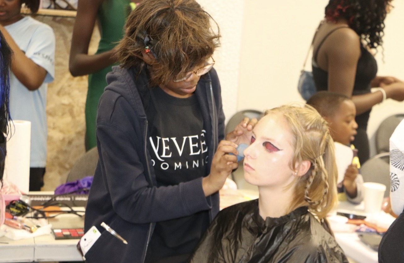 A participant applies makeup during the Summer Beauty and Leadership Camp