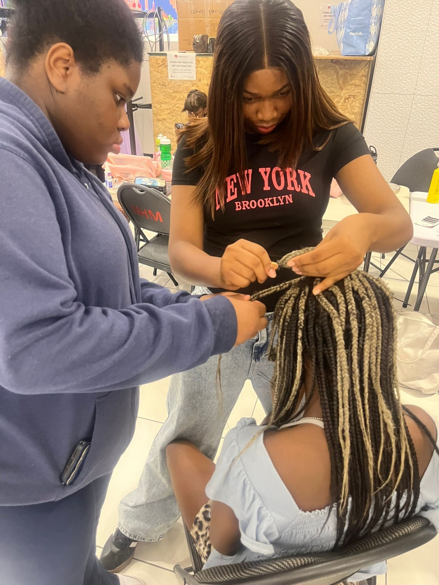 A student and a mentor finish braiding before the graduation showcase