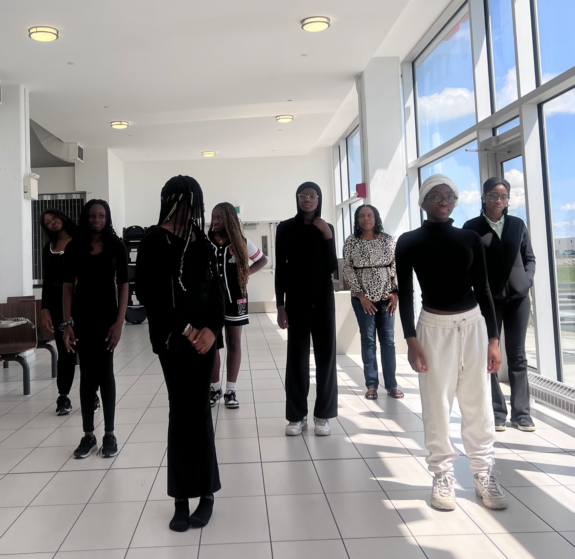 Camp participants lined up together in a bright, sunlit hallway