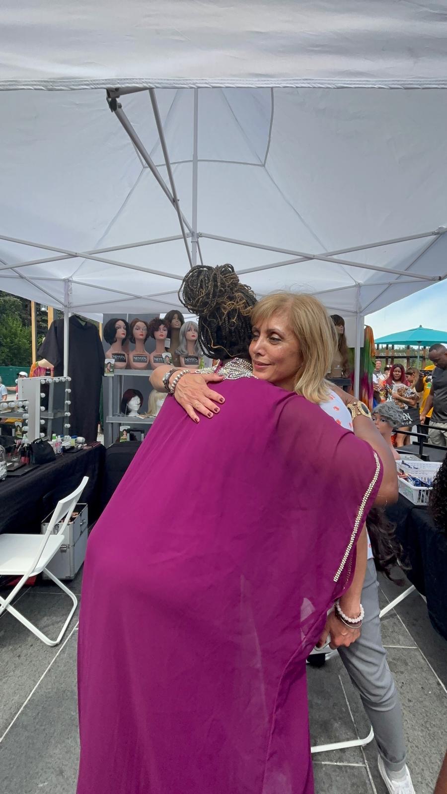 The founder embracing a guest at the booth