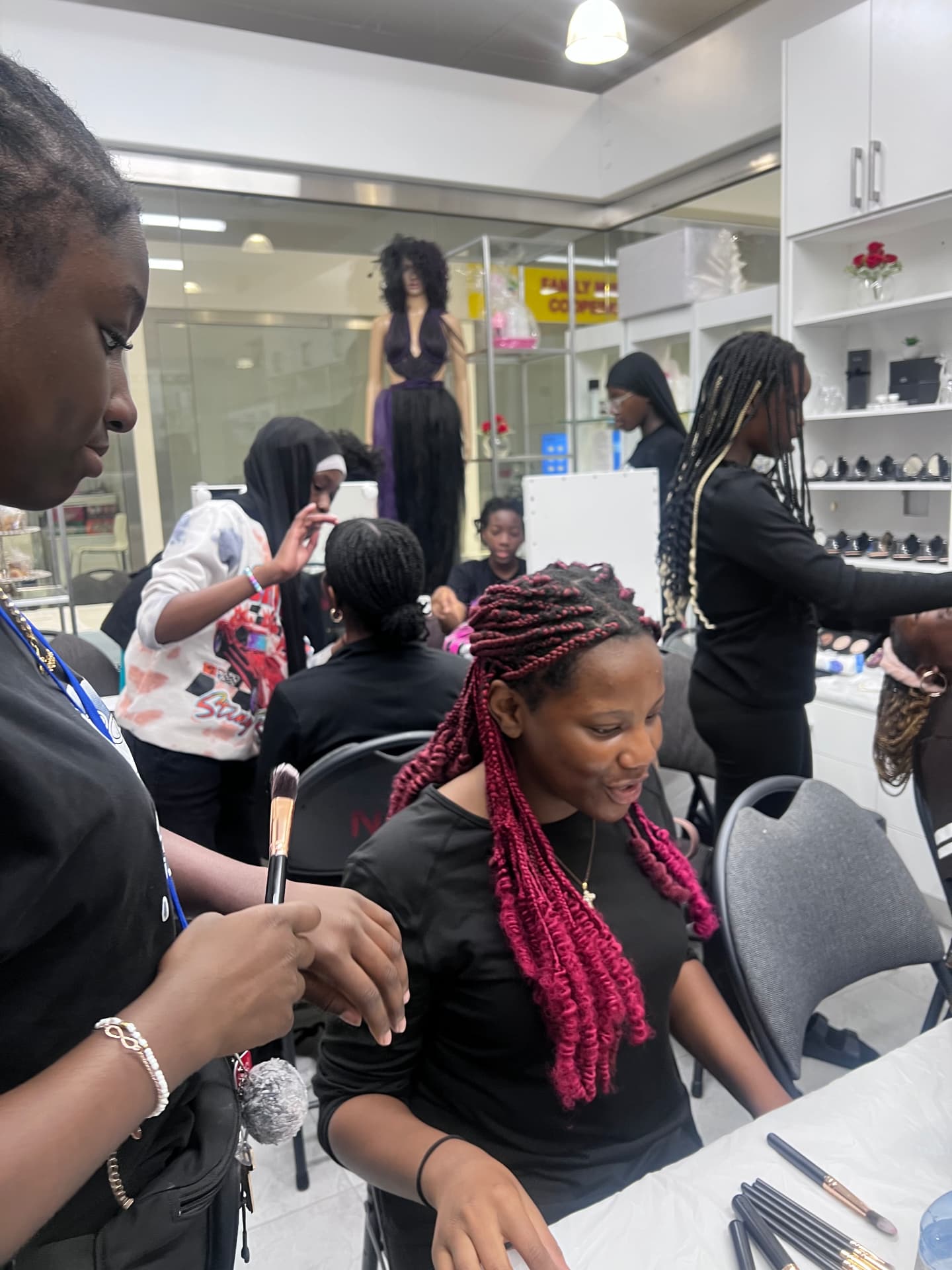 A participant applies makeup while another camper waits
